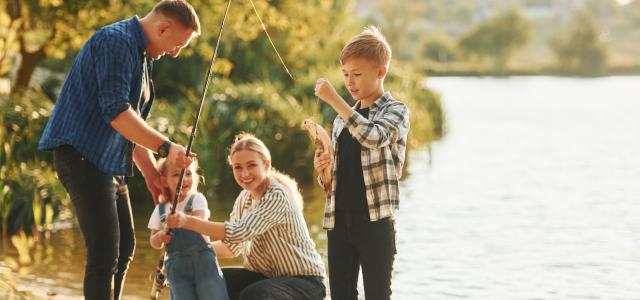 Family of four fishing on the edge of a lake